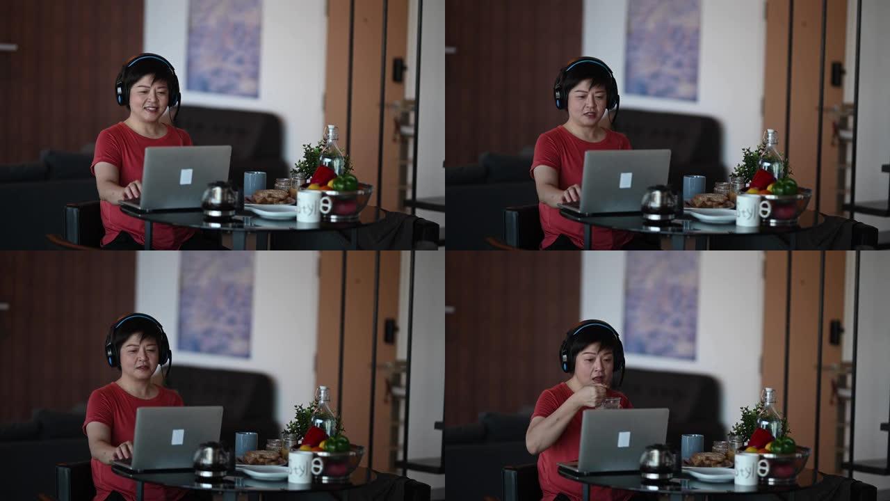 一名亚洲中国中年成年人在餐厅吃早餐，早上用笔记本电脑回复电子邮件