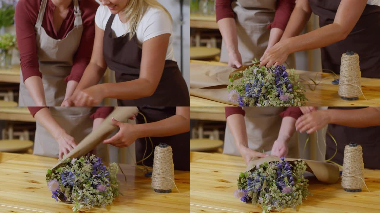 两个快乐的花店将花束包裹在一起
