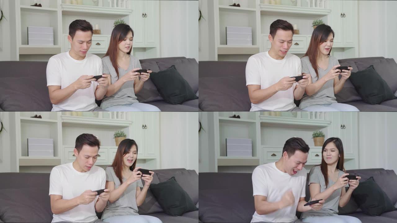 4K UHD: 亚洲夫妇使用智能手机并在手机上玩游戏，早上在沙发上玩得开心。