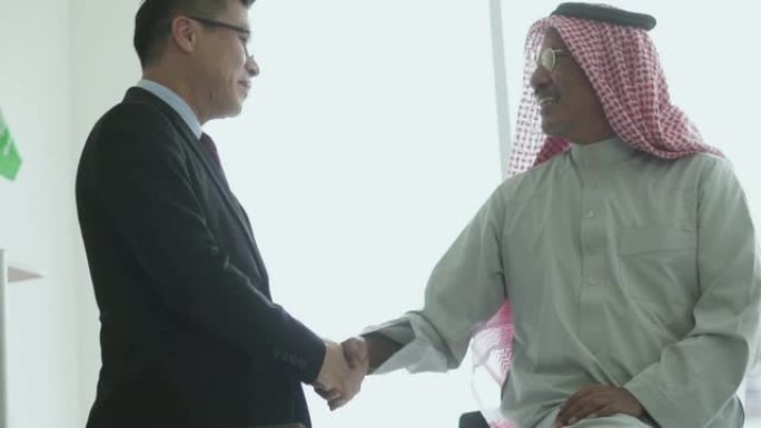快乐的阿拉伯男人与他的商业伙伴握手