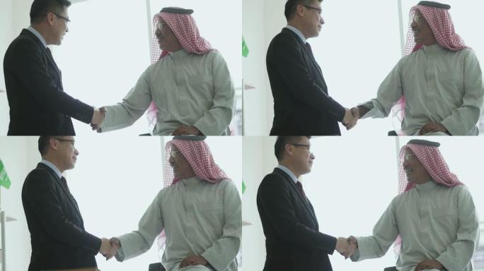 快乐的阿拉伯男人与他的商业伙伴握手