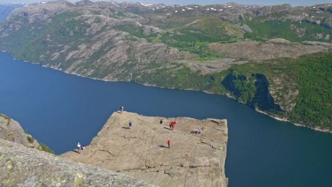 Preikestolen，又名挪威传教士的椅子。站在悬崖边上欣赏美景的游客。峡湾在背景中