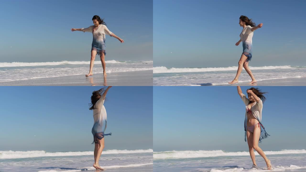 年轻女子在阳光下的海滩上跳舞4k