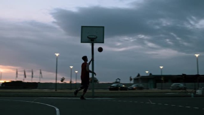 WS年轻人在黄昏时在室外篮球场打篮球