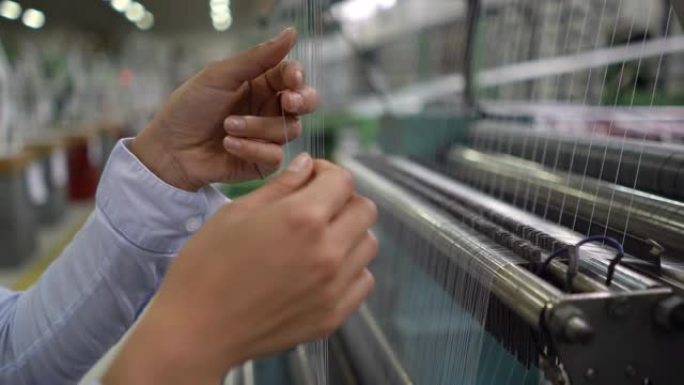 无法识别的女工在工厂检查橡胶线的生产