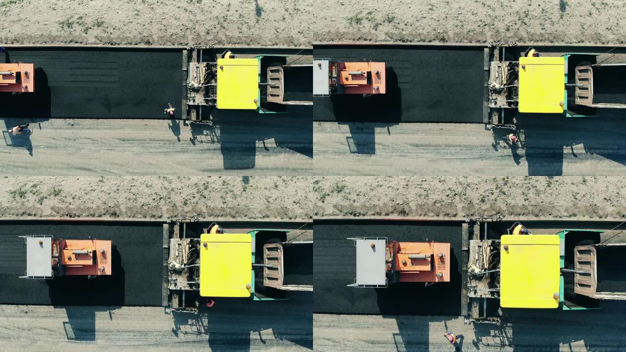 道路施工现场的沥青摊铺机。道路机械铺设沥青的俯视图