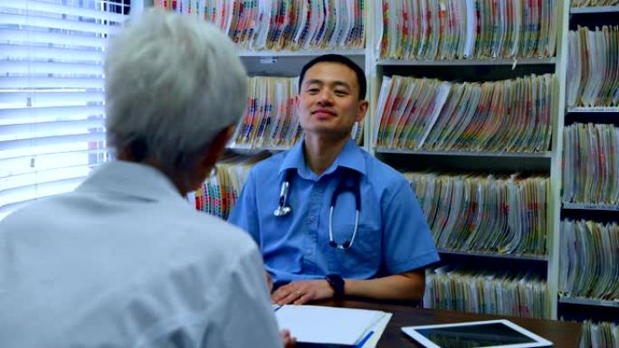 年轻的亚洲男性医生和高级患者在诊所4k相互交流