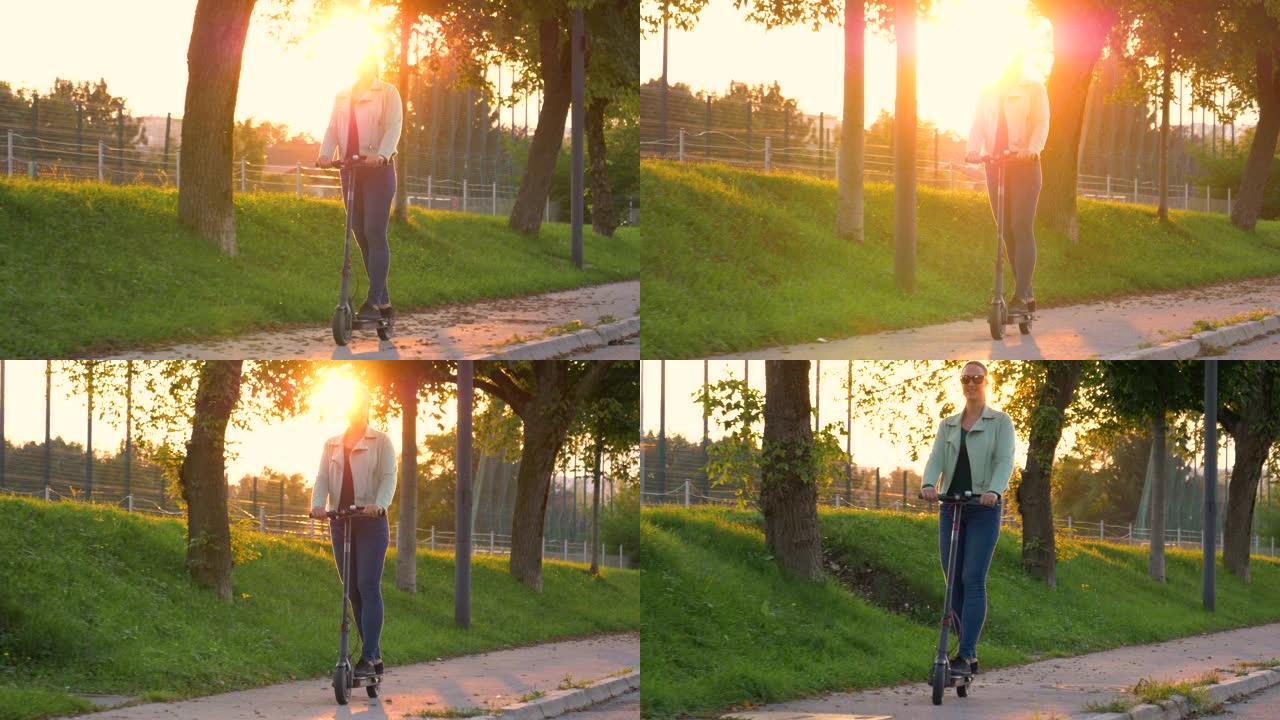 太阳耀斑: 快乐的女孩在日落时骑着电动踏板车穿过公园时微笑