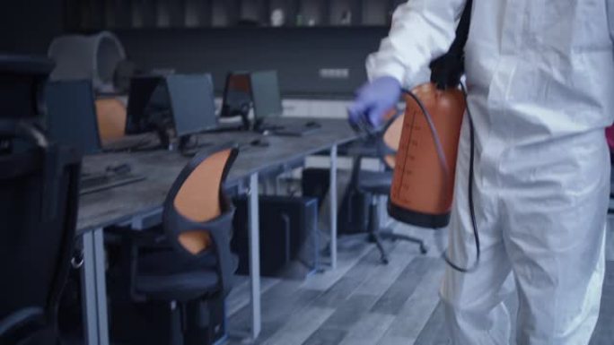 穿着危险品套装消毒办公室的男人