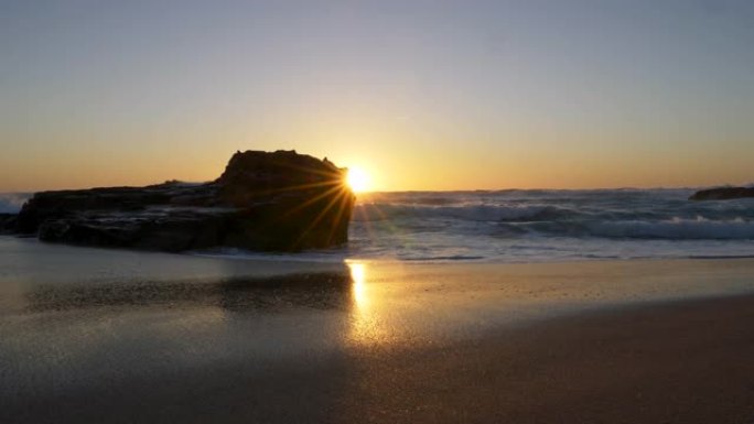 葡萄牙大西洋沿岸美丽的沙滩。太阳被视为一颗从岩石外闪耀的多波束恒星。UHD