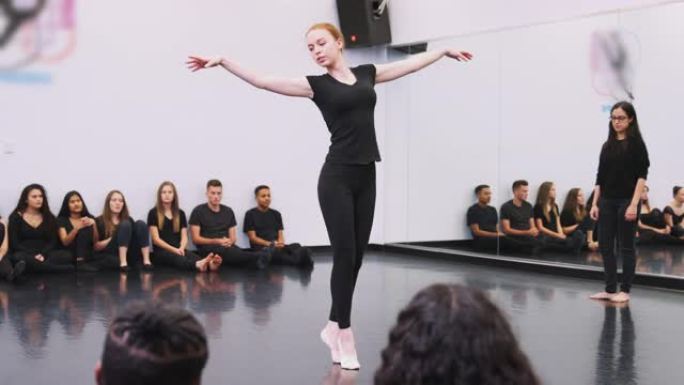 表演艺术学校的女芭蕾舞学生在舞蹈工作室为班级和老师表演