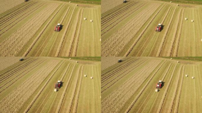 农业拖拉机的航拍正在田野上收集稻草，以便在晴天制作干草。