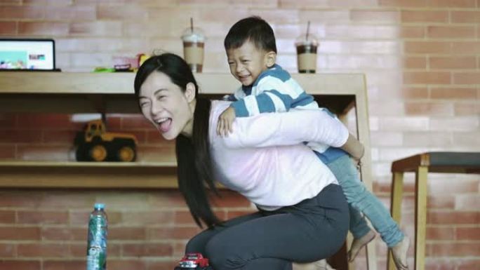 亚洲单亲妈妈带着儿子的4k慢动作镜头在现代阁楼房子里一起玩耍，充满幸福的生活，以实现自我学习或家庭学