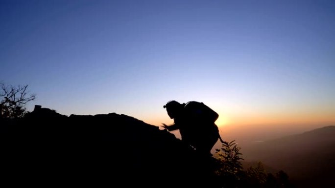 4K RT WS男子爬到山顶，并用太阳光抬起手臂。