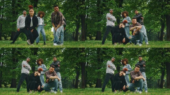 一群不同种族的年轻城市舞者的慢动作在阳光明媚的日子里在绿色的城市公园里训练