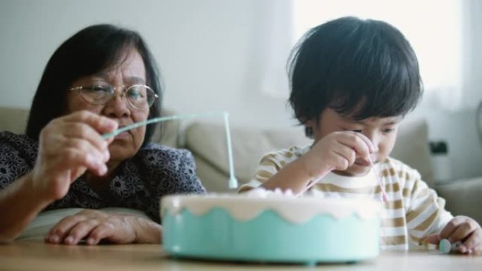 亚洲祖母和孙子在家里玩玩具。
