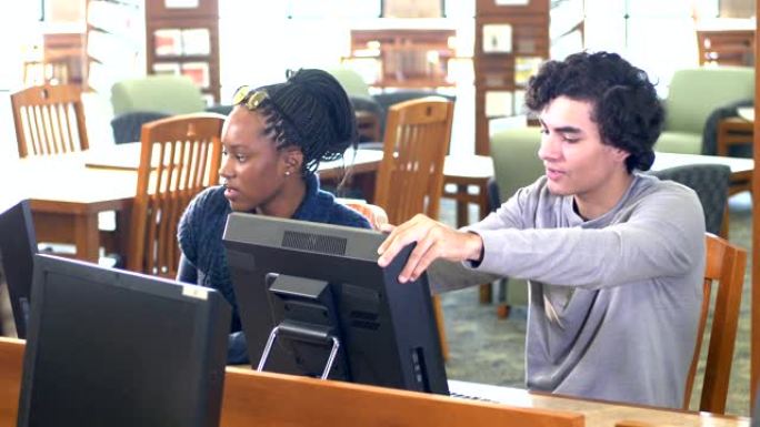 高中生在图书馆计算机上共同工作