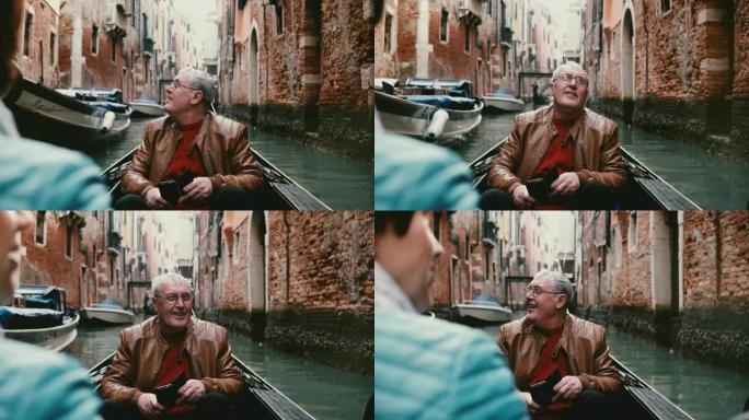 兴奋的高级欧洲男性旅行者在贡多拉微笑，环顾四周，进行美丽的威尼斯运河之旅。