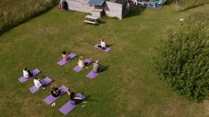在户外瑜伽静修会上，成熟男女老师领导小组的无人机拍摄