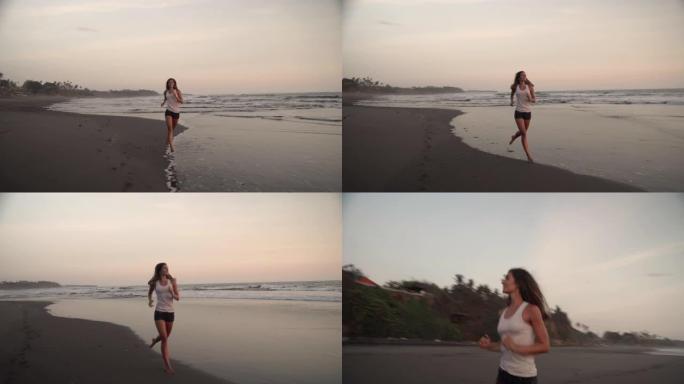 快乐的年轻女子沿着海洋海岸线在沙滩上奔跑