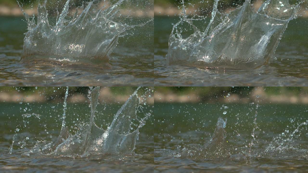 宏观: 卵石掉入河中后，晶莹剔透的水在电影中飞溅。