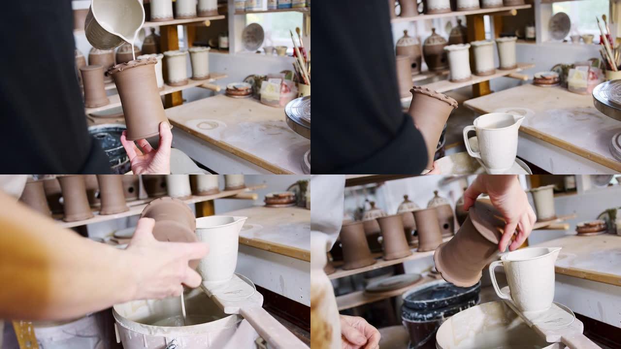 陶瓷工作室中男性陶工在粘土花瓶上施釉的特写