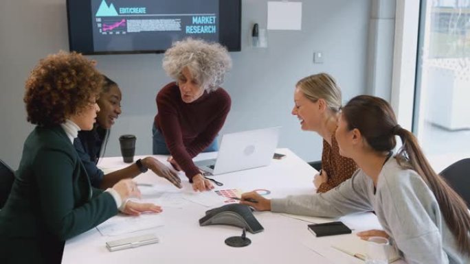 成熟的女商人领导的女性创意会议在现代办公室里围桌合作