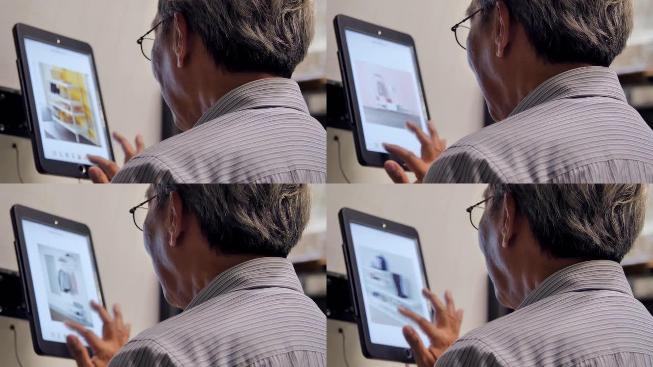 高级男子在购物时在平板电脑上查找订单详细信息。高级男子使用触摸屏设备进行在线购物。技术，人员，创新，