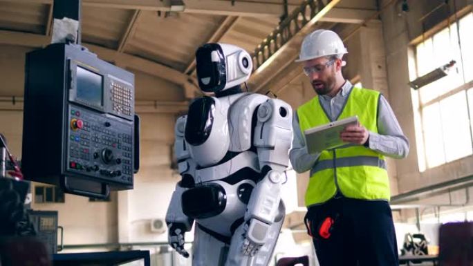 人检查工作机器人，站在工厂里。