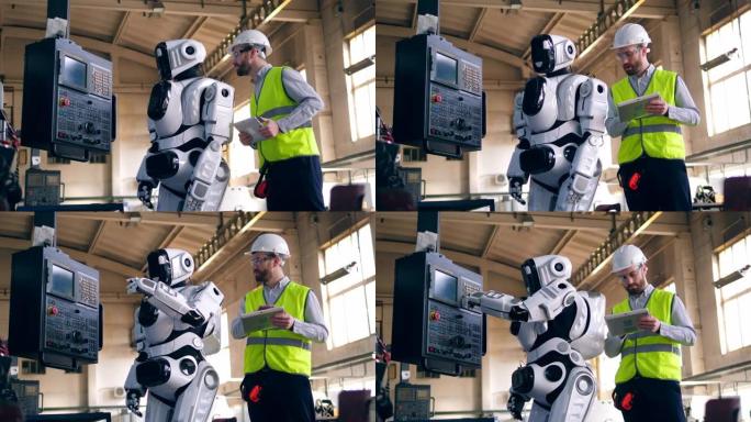 人检查工作机器人，站在工厂里。