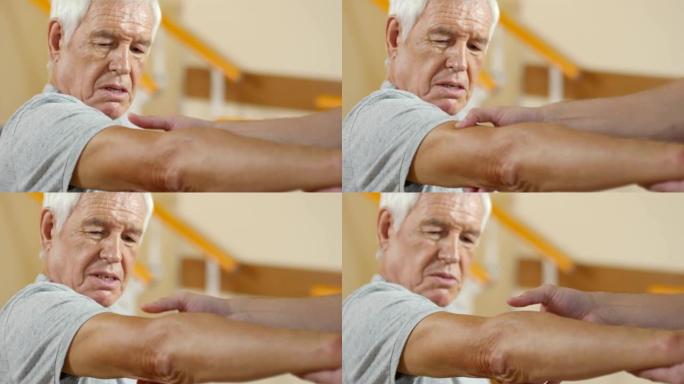 无法识别的理疗师检查老人的手臂