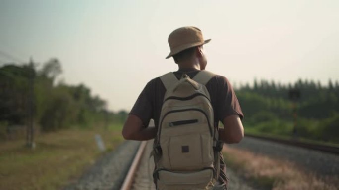 在铁路上行走的男性背包客的特写