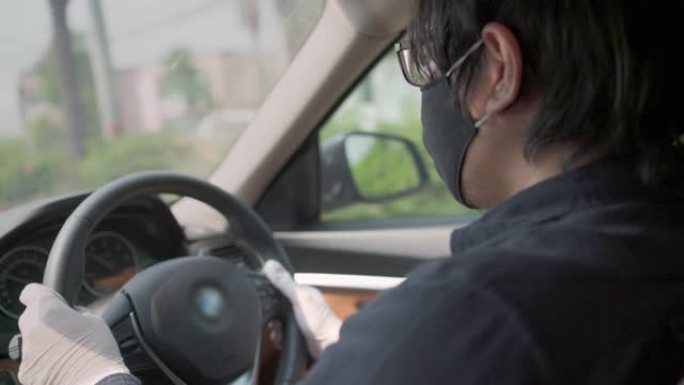 出租车司机在开车时戴防护面罩和塑料手套