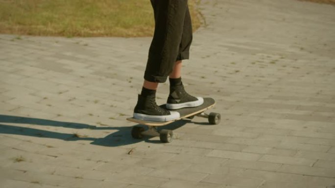 酷酷的年轻女孩戴着豆豆和圆形太阳镜骑着滑板穿过城市时尚的臀部文化部分。在滑板公园玩滑板。拍摄后的慢动