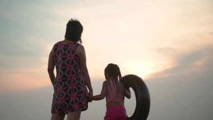 一个女孩和她的祖母站在海滩上
