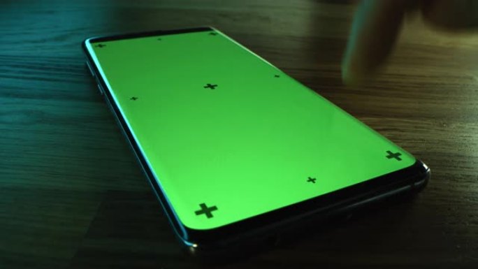 特写微距: 现代绿色模拟屏幕智能手机躺在桌子上，人们使用它。做手势的人: 滑动、触摸、推动、滚动。色