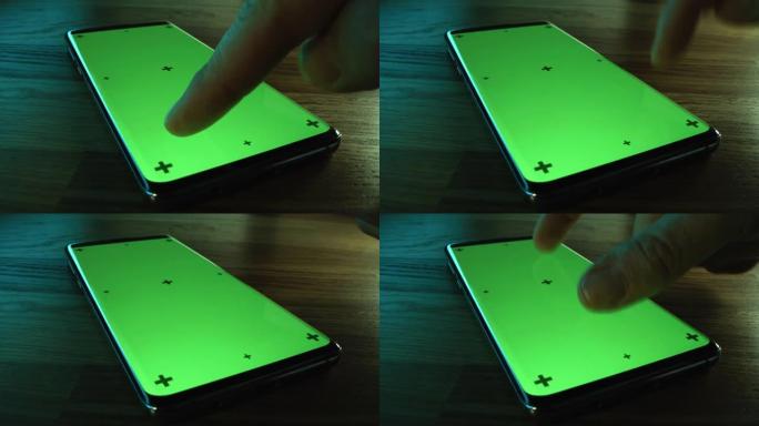 特写微距: 现代绿色模拟屏幕智能手机躺在桌子上，人们使用它。做手势的人: 滑动、触摸、推动、滚动。色