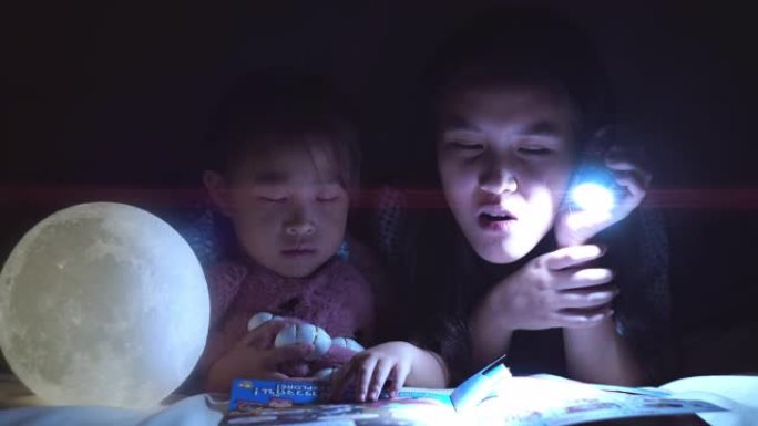 姐姐在睡前读故事给年轻人