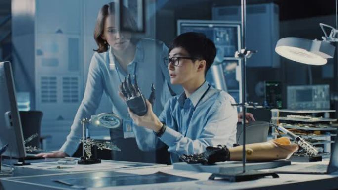 技术假肢机器人手臂由两名专业开发工程师在高科技研究实验室中使用现代未来设备进行测试。男人和女人在个人