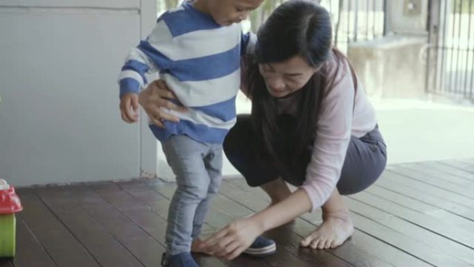 4k慢动作镜头亚洲单身妈妈洁具鞋给儿子充满幸福生活在现代阁楼房子的自我学习或家庭学校，家庭和童年概念