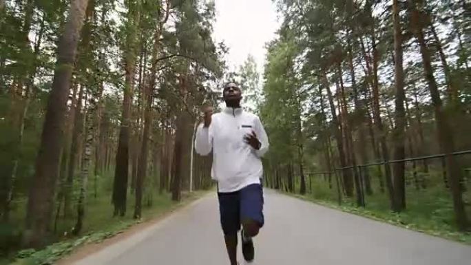 男跑者沿着森林路慢跑