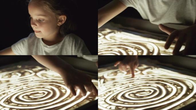 可爱的小女孩用沙子画画
