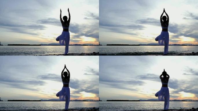 年轻女子正在山海、日出、日落练习瑜伽