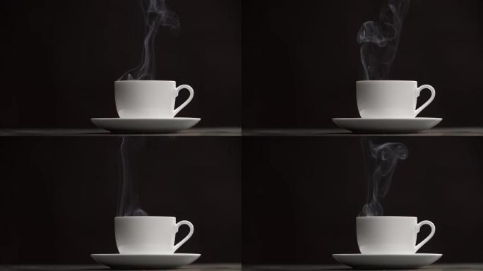白茶或咖啡杯和茶托在黑色背景下的桌子上。蒸汽 (烟雾) 从杯子里冒出来