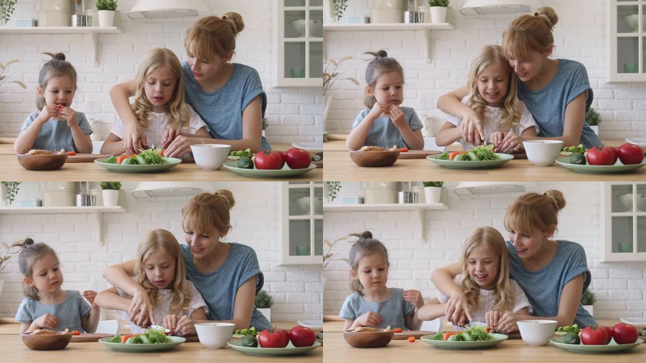 年轻的母亲教孩子女儿在厨房切蔬菜沙拉