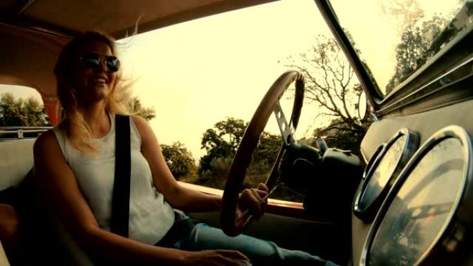 戴着金色头发的太阳镜微笑的女人开车
