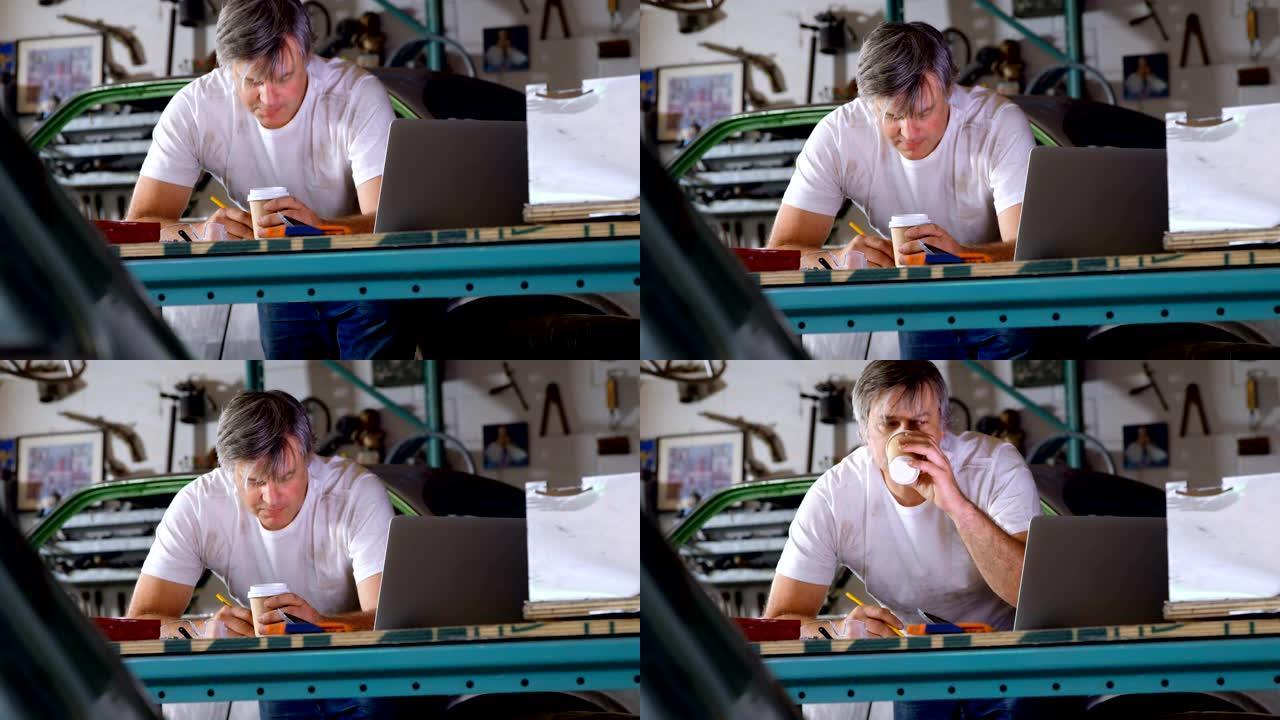 男性机械师在4k桌边写字边喝咖啡