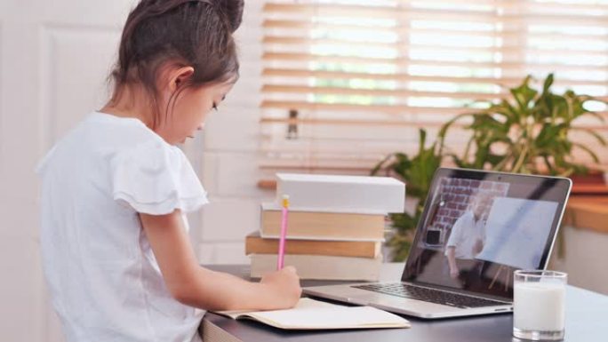 亚洲小女孩年龄6-7岁在家学习在线课程。儿童教育概念，电子学习，家庭教育，学生，社交距离，视频通话，