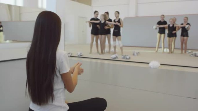 年轻女子在啦啦队训练中指导女孩