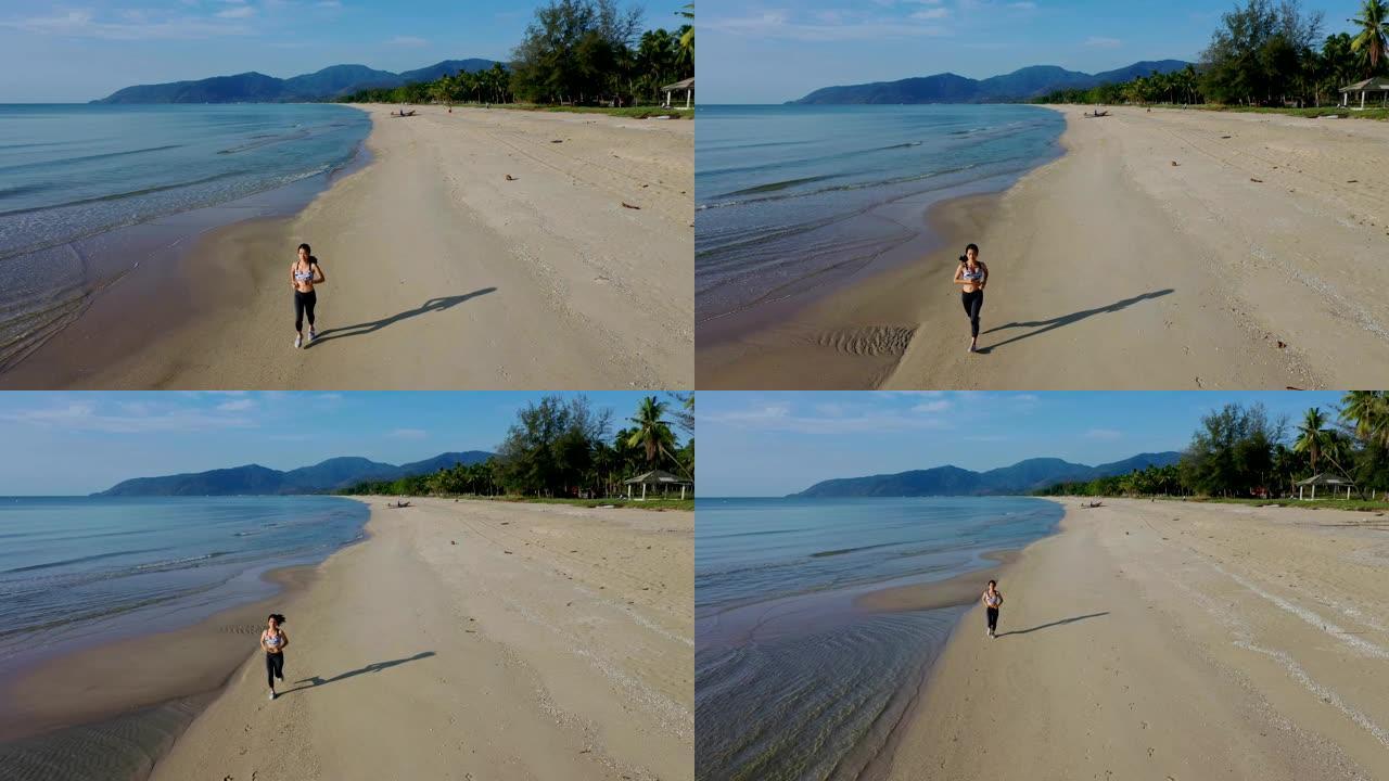 空中追踪拍摄运动慢跑者亚洲女子早上在海滩上跑步
